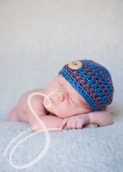 Newborn on gray blue and brown hat