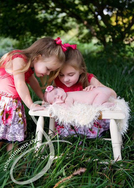 newborn girl outside with sisters